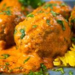 Close-up venison meatballs in an Indian-style yoghurt-based curry sauce with pilau rice.