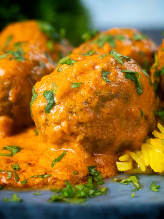 Close-up venison meatballs in an Indian-style yoghurt-based curry sauce with pilau rice.