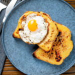 Overhead Welsh rarebit or British cheese on toast with a fried egg.