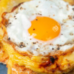 Fried egg served on top of Welsh rarebit or British cheese on toast aka buck rarebit featuring a title overlay.