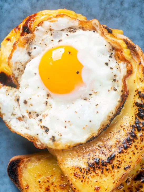 Close-up overhead Welsh rarebit or British cheese on toast with a fried egg.