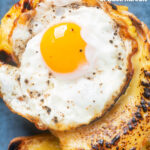 Close-up overhead Welsh rarebit or British cheese on toast with a fried egg featuring a title overlay.