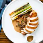 Overhead sliced chicken breast forestiere or mushrooms in a creamy brandy sauce.