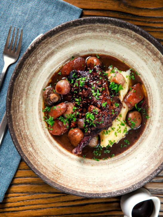 Overhead coq au vin with carrots, mushrooms bacon and shallots served with mashed potato.