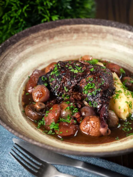 French coq au vin with carrots, mushrooms bacon and shallots served with mashed potato.