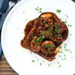Overhead classic British devilled lambs kidneys on toast with snipped chives.