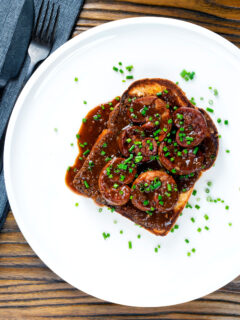 Overhead classic British devilled lambs kidneys on toast with snipped chives.