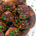 Close up overhead classic British devilled lambs kidneys on toast with snipped chives featuring a title overlay.