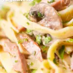 Close up creamy ham and mushroom pasta with fresh parsley featuring a title overlay.