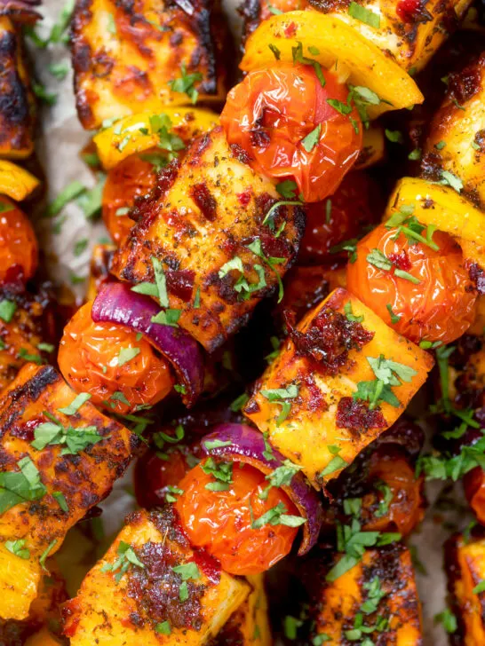 Overhead close-up harissa halloumi and vegetable kebab skewers.