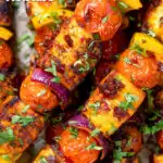 Overhead close-up harissa halloumi and vegetable kebab skewers featuring a title overlay.