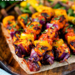 Harissa halloumi and vegetable kebabs served with a spicy mango salad featuring a title overlay.