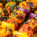 Close-up harissa halloumi and vegetable kebab skewers.