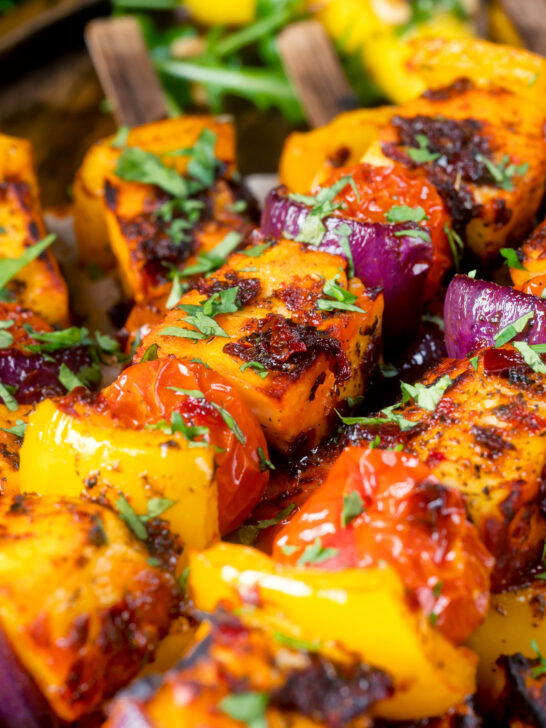 Close-up harissa halloumi and vegetable kebab skewers.