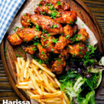 Overhead sticky date and harissa chicken wings served with French fries and salad featuring a title overlay.