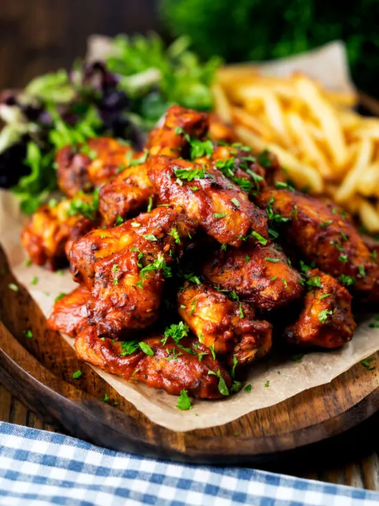 Sticky date and harissa chicken wings served with French fries and salad.