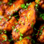 Close-up spicy, sweet and sour sticky date and harissa chicken wings.