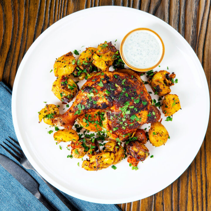 Indian spiced roast chicken legs served with roasted Bombay potatoes.