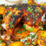 Indian spiced roast chicken legs served with onion, Bombay potatoes and raita featuring a title overlay.