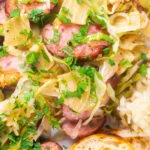 Overhead close-up Polish noodles or lazanki with kielbasa sausage, cabbage and sauerkraut.