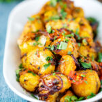 Oven roast Bombay potatoes or Bombay aloo with fresh coriander.