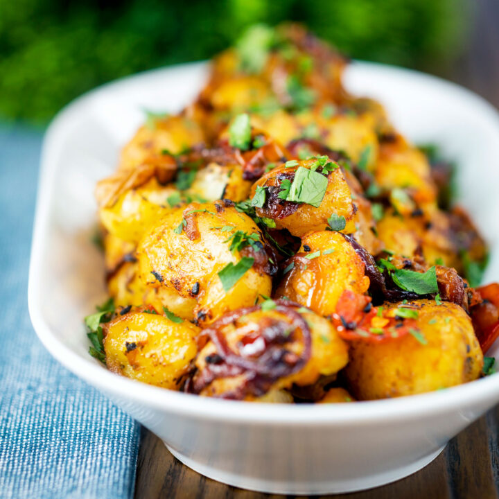 Roast Bombay potatoes or Bombay aloo with onions and tomatoes.