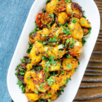 Overhead oven roast Bombay potatoes or Bombay aloo with fresh coriander.