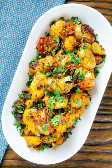 Overhead oven roast Bombay potatoes or Bombay aloo with fresh coriander.