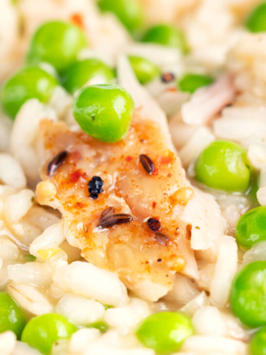 Close up smoked mackerel risotto with sweet peas and chilli flakes.