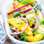 Spicy mango salad with chilli, red onion, rocket (arugula), lime and pine nuts.