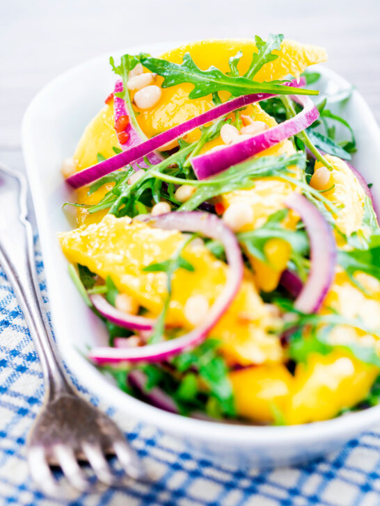 Spicy mango salad with chilli, red onion, rocket (arugula), lime and pine nuts.