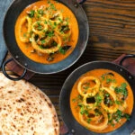 Overhead Indian-influenced squid ring curry in a coconut sauce.