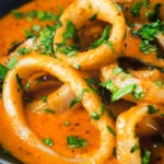 Close-up Indian-influenced calamari ring curry in a spicy coconut sauce.