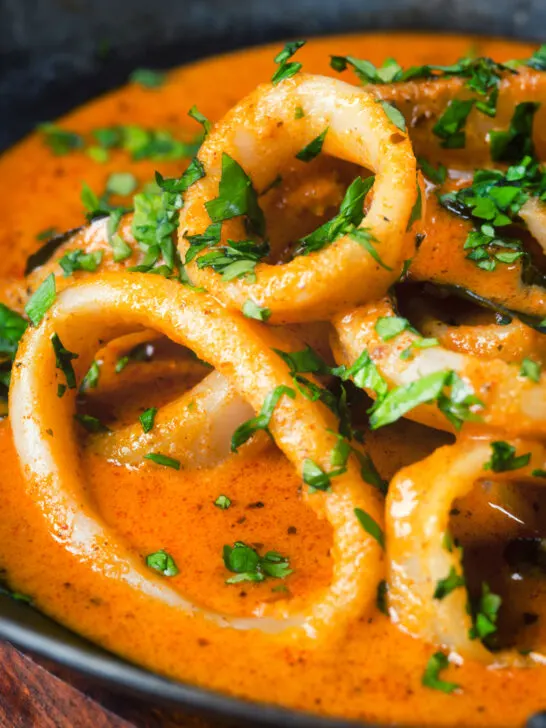 Close-up Indian-influenced calamari ring curry in a spicy coconut sauce.