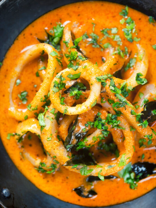 Close-up overhead Indian-influenced calamari ring curry in a spicy coconut sauce.