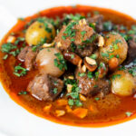 Close-up Spicy Thai beef massaman curry with potatoes, shallots and peanuts.