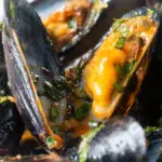 Close-up spicy Thai inspired red curry mussels.