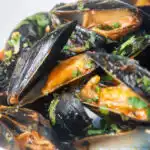 Close-up Thai inspired red curry mussels in a coconut milk sauce.