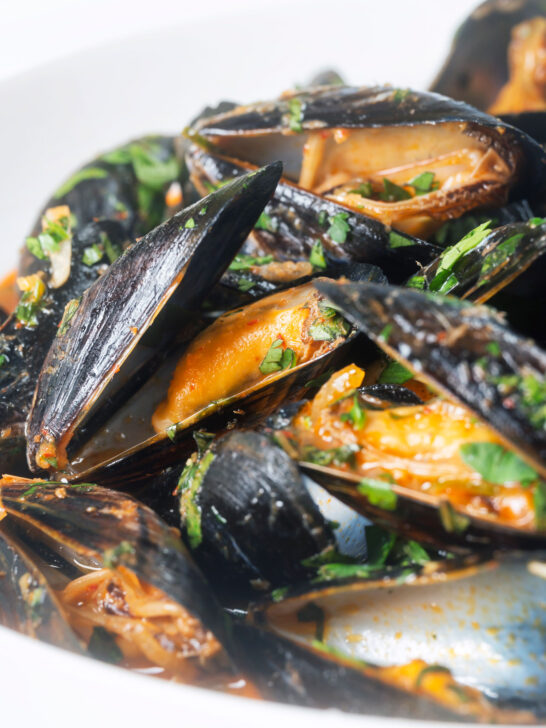 Close-up Thai inspired red curry mussels in a coconut milk sauce.