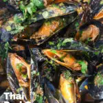 Overhead close-up Thai inspired red curry mussels in a coconut milk sauce featuring a title overlay.