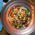Overhead soy sauce tofu and rice vermicelli noodle salad with lots of veggies.