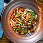 Overhead soy sauce tofu and rice vermicelli noodle salad with lots of veggies.
