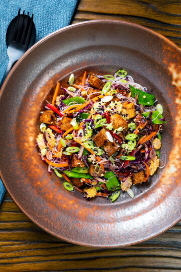 Overhead soy sauce tofu and rice vermicelli noodle salad with lots of veggies.