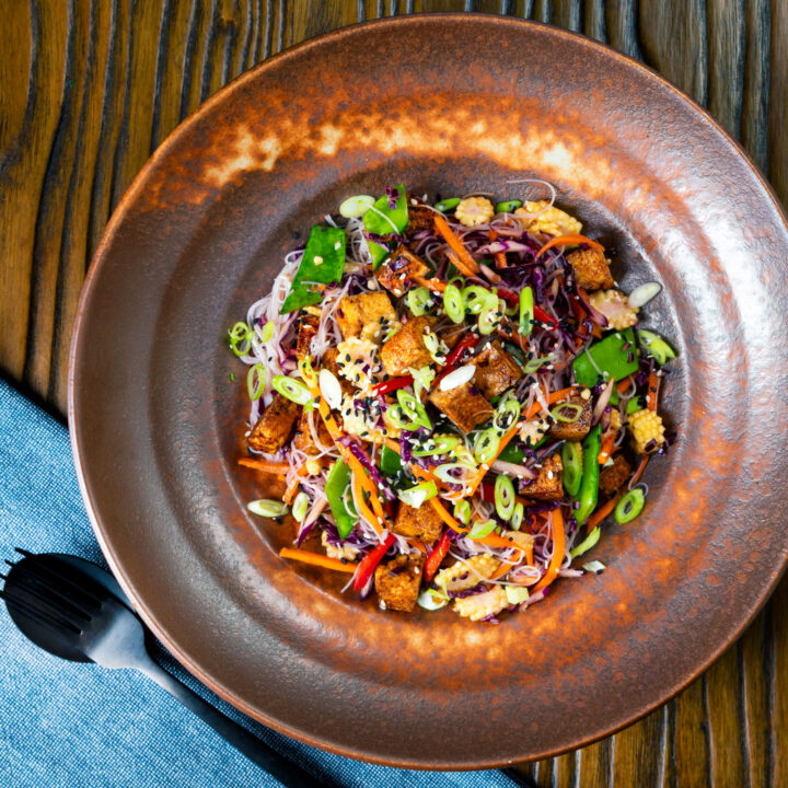 Vegan fried tofu noodle salad with rice noodles and lots of fresh vegetables.