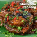 Close-up vegan mushroom rendang curry with coconut milk featuring a title overlay.