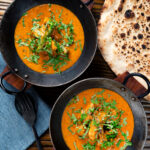 Overhead Indian coconut milk chicken curry with tamarind and fresh coriander.