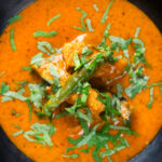Overhead close-up Indian coconut milk chicken curry with tamarind and fresh coriander.