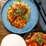Overhead duck leg tagine with Moroccan flavours served with buttered couscous and fresh coriander.