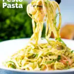 Prawn pesto pasta with basil pesto, jumbo shrimp and linguine being picked up with a fork featuring a title overlay.