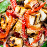 Overhead close-up grilled and marinated halloumi salad with peppers, couscous and chickpeas.